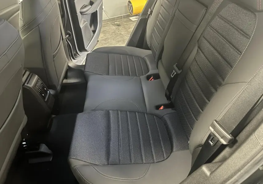 Vue intérieure sur la banquette arrière en sellerie AlfaTec noire avec surpiqûres rouges d'une Alfa Romeo Tonale gris foncé.