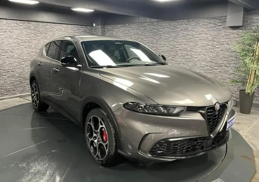Alfa Romeo Tonale gris foncé vue 3/4 avant droit, jantes alliage 19 pouces et rétroviseurs noirs brillants.