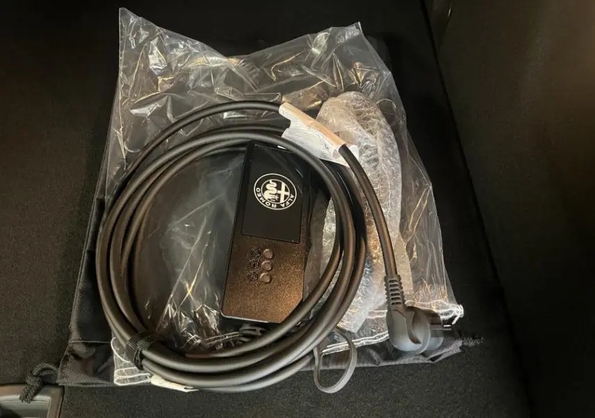 Câble de recharge Alfa Romeo Tonale 1.3 PHEV gris foncé, vu en gros plan sur fond noir intérieur de coffre.
