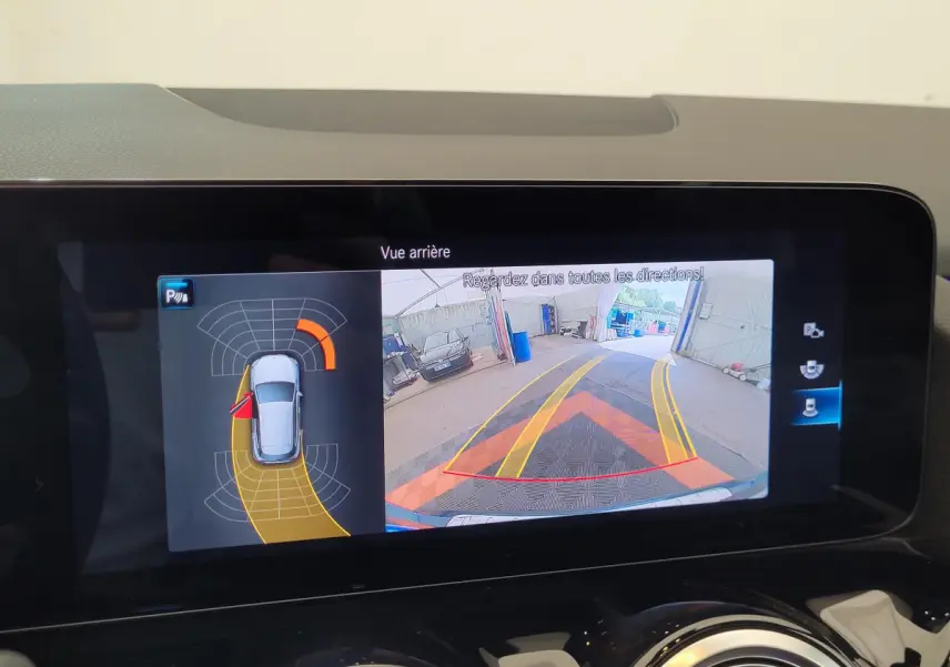 Écran tactile du tableau de bord affichant la caméra de recul et l'aide au stationnement du Mercedes GLA bleu 2022.