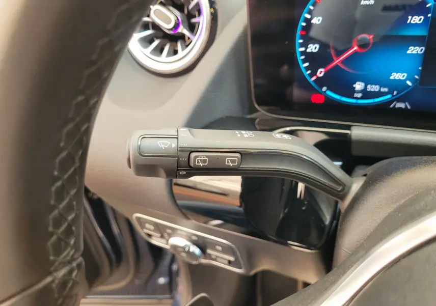 Gros plan sur la manette d'essuie-glace à gauche du volant cuir du Mercedes GLA 200 D bleu 2022, tableau de bord numérique visible.