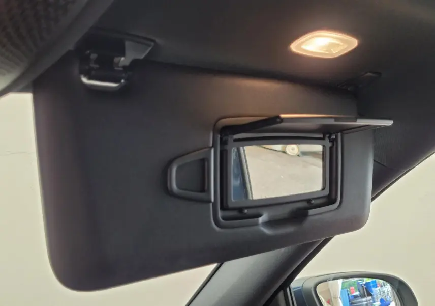Miroir de courtoisie ouvert sur le pare-soleil côté conducteur d’un Mercedes GLA 200 D bleu, intérieur noir.