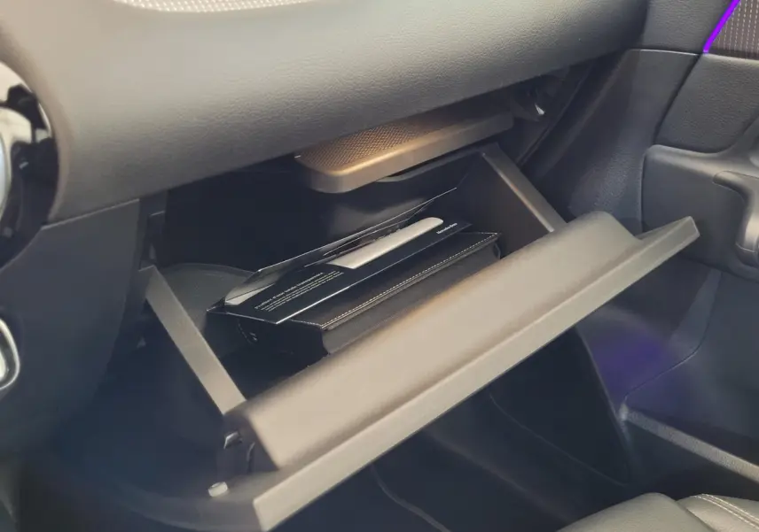 Gros plan sur la boîte à gants ouverte côté passager d'une Mercedes GLA 200 D Business Line 2022, intérieur noir.
