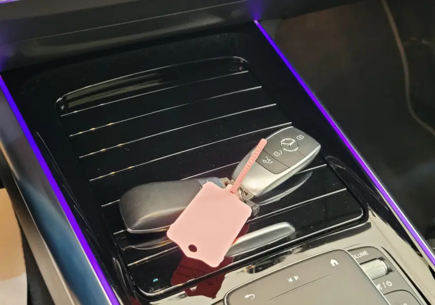 Gros plan sur la console centrale noire brillante avec clé Mercedes et éclairage d'ambiance violet du Mercedes GLA bleu 2022.