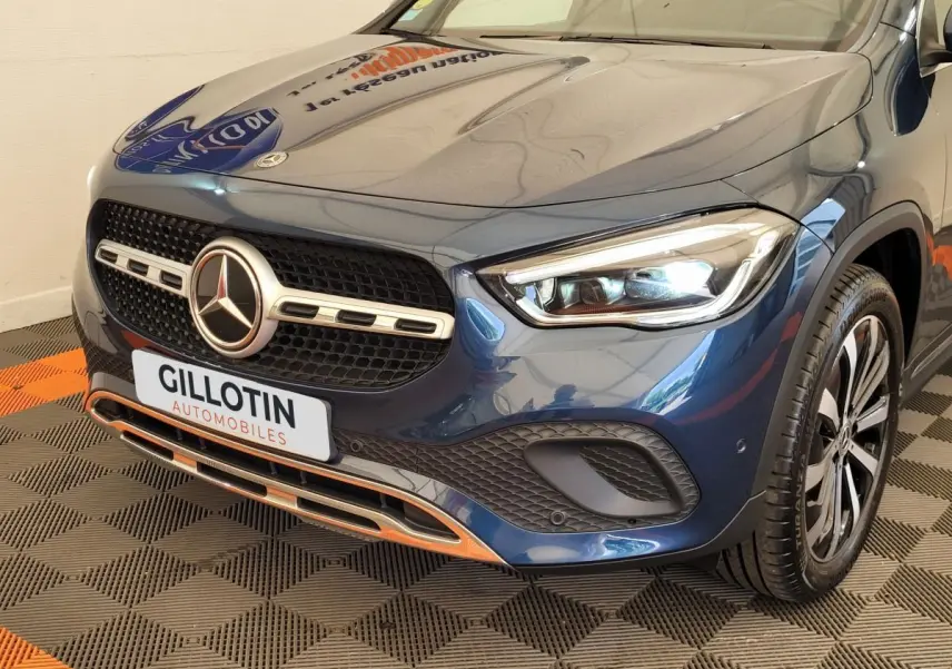 Vue 3/4 avant droit d'une Mercedes GLA 200 d Business Line bleu métallisé avec calandre et phares LED distinctifs.