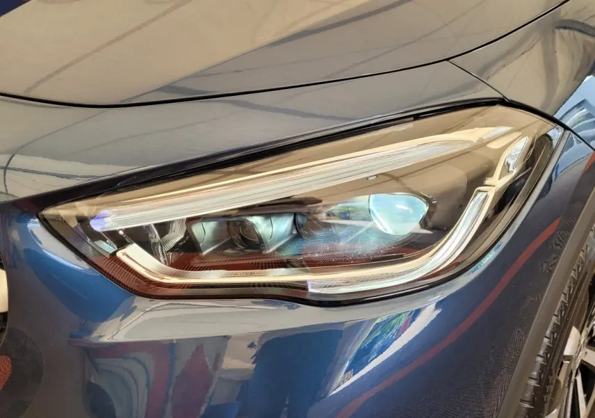 Gros plan sur le phare avant droit LED d'un Mercedes GLA 200 D Business Line bleu 2022.