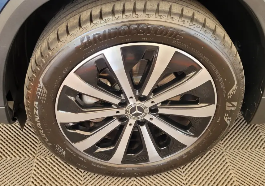 Gros plan sur la jante alliage bicolore et pneu Bridgestone d'une Mercedes GLA 200 D Business Line bleu 2022.