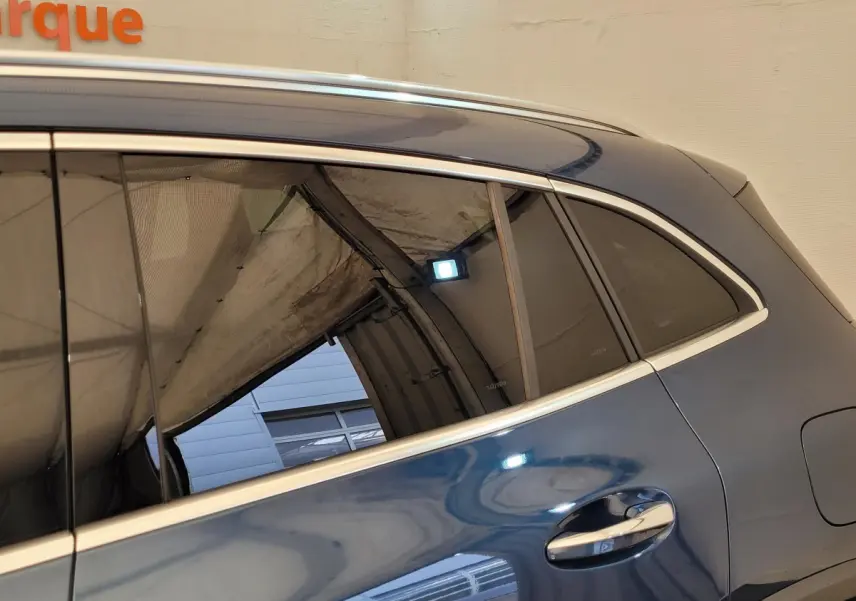 Vue latérale côté droit d'une Mercedes GLA 200 d Business Line 2022 bleu métallisé avec poignées chromées.