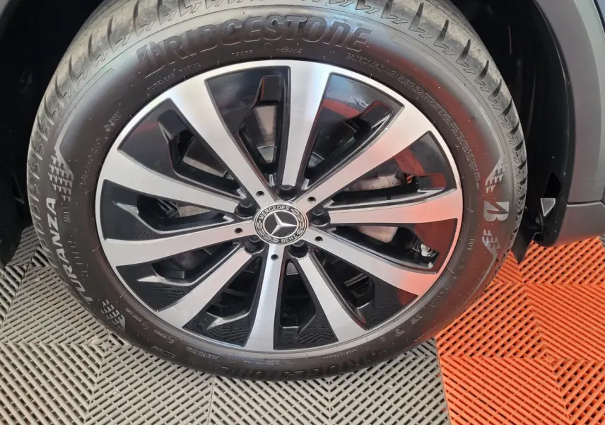 Gros plan sur la jante alliage bicolore et pneu Bridgestone d'un Mercedes GLA 200 D bleu 2022
