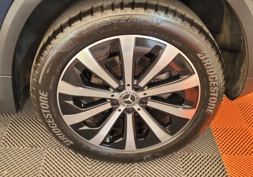 Gros plan sur la roue avant droite du Mercedes GLA 200 D Business Line bleu avec jante alliage bicolore et pneu Bridgestone.