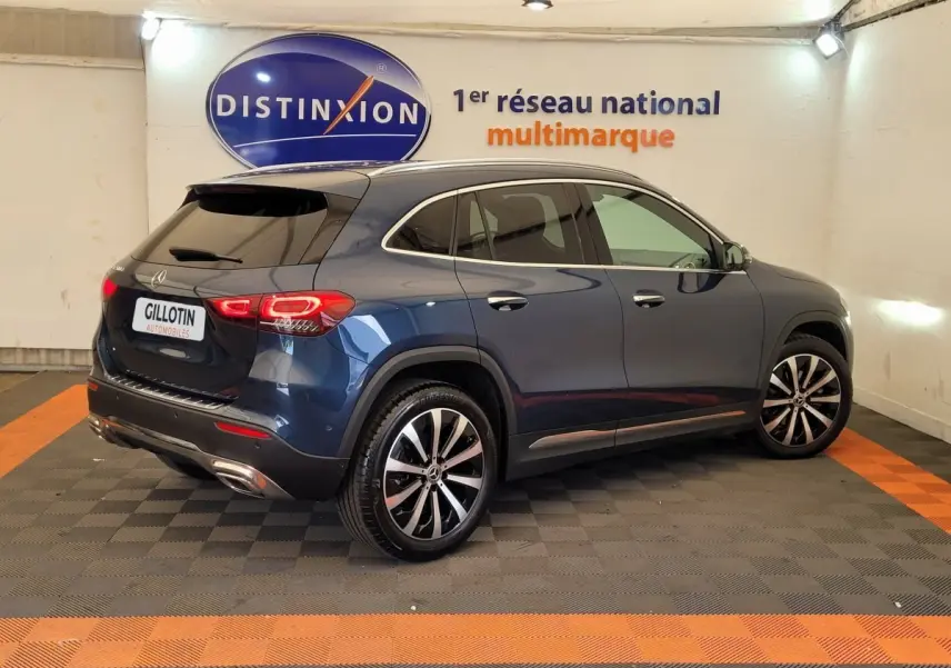 Vue 3/4 arrière droite d'un Mercedes GLA 200 D Business Line bleu métallisé avec jantes alliage et vitres teintées.