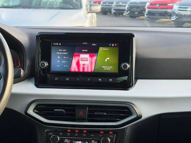 Vue intérieure centrée sur l'écran tactile du tableau de bord de la SEAT Ibiza 2025, finition Xcellence, avec commandes climatisation visibles.