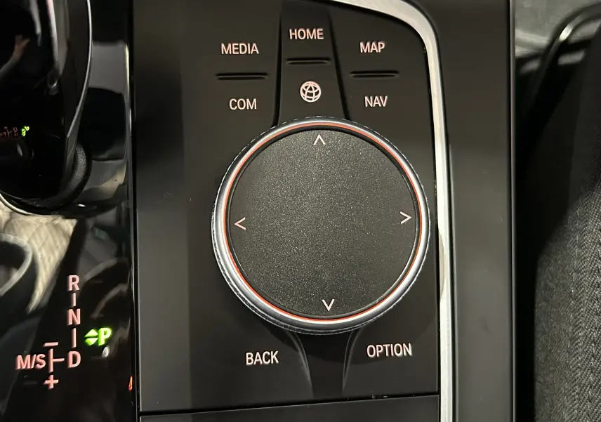 Gros plan sur la molette de commande centrale et levier de vitesses de la BMW Série 1 116d noire de 2023.