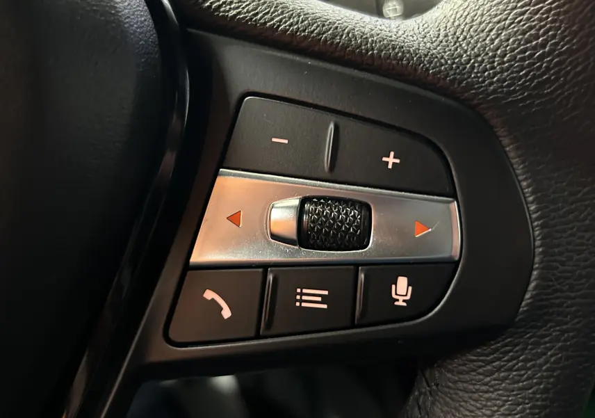 Gros plan sur les commandes multifonctions côté gauche du volant en cuir noir d'une BMW Série 1 116d 2023.