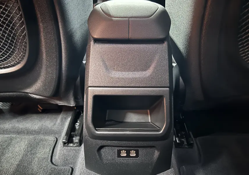 Vue rapprochée de la console centrale arrière noire de la BMW Série 1 116d 2023 avec ports USB visibles au bas.