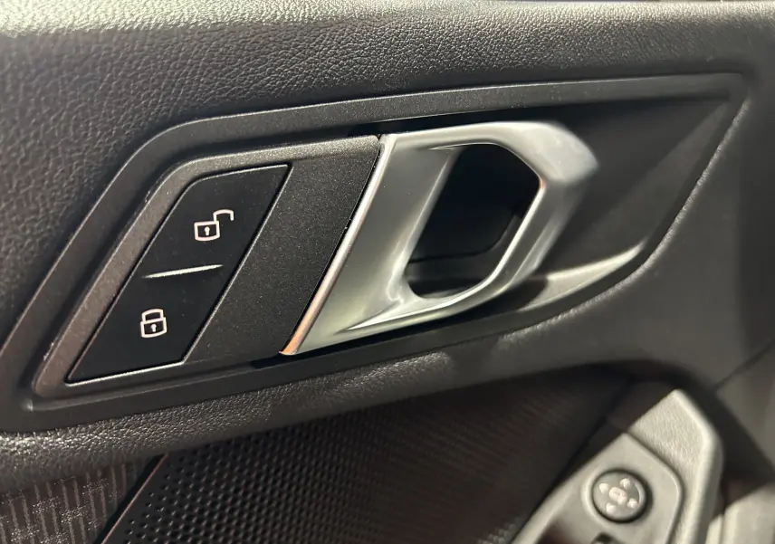 Poignée intérieure de porte côté gauche noire avec boutons de verrouillage, sur BMW Série 1 116d 2023 finition GPS Virtual.