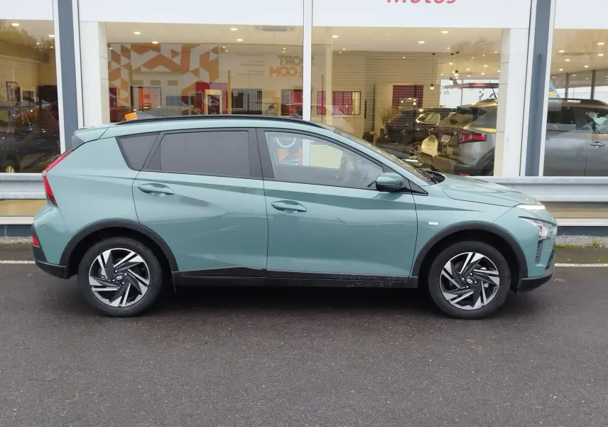 Vue de profil droit d’un Hyundai Bayon 2022 hybride en couleur Elemental Brass Metal avec jantes alliage et vitres teintées.