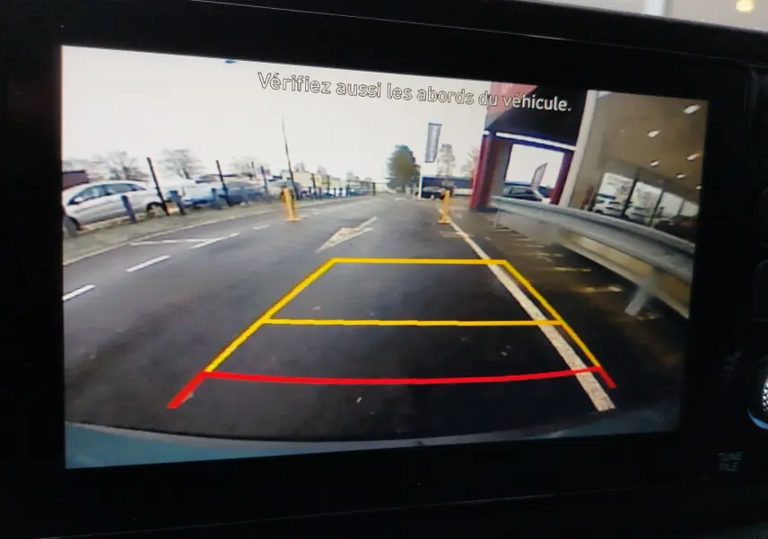 Vue caméra de recul du Hyundai Bayon 2022 en couleur Elemental Brass Metal, affichant les lignes d’aide au stationnement.