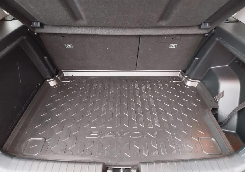 Vue rapprochée de la malle arrière ouverte d’un Hyundai Bayon 2022, avec tapis de coffre noir marqué BAYON.