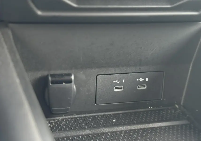 Gros plan sur les deux ports USB-C et prise 12V dans le rangement central noir du Renault Symbioz E-Tech Full Hybrid 2025.