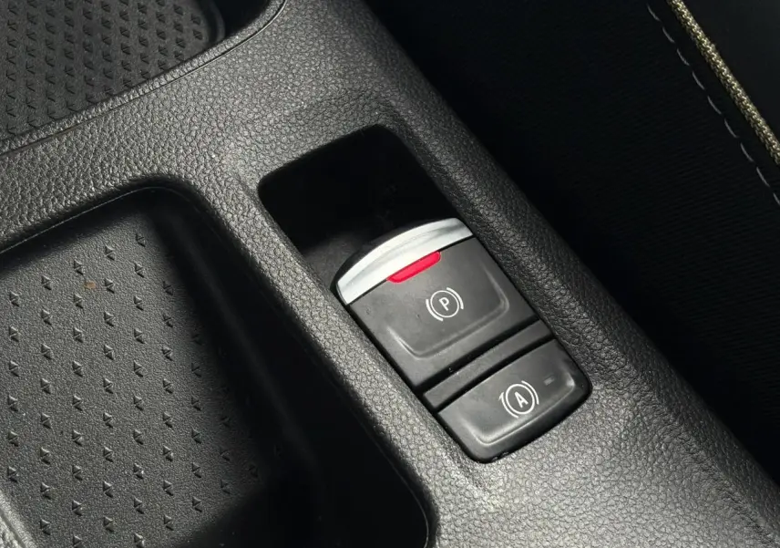 Gros plan sur les commandes de frein de parking et d'assistance au démarrage du Renault Symbioz 2025, intérieur noir.