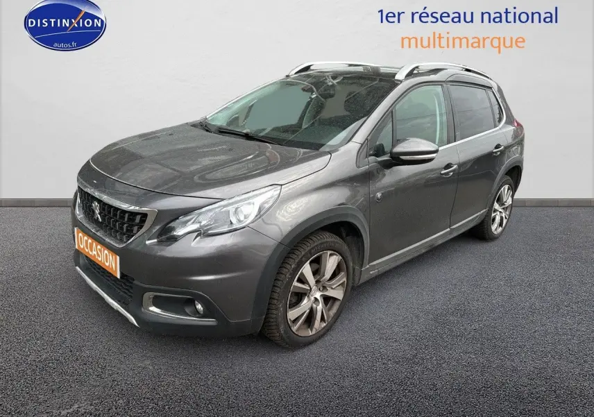 Peugeot 2008 gris platinium en 3/4 avant droit, avec jantes alliage et barres de toit visibles.