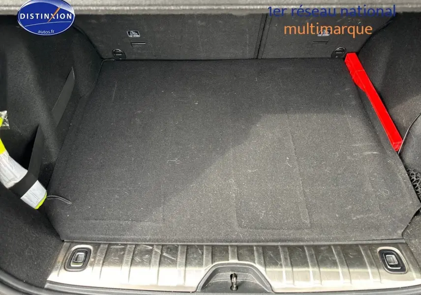 Coffre ouvert du Peugeot 2008 gris platinium, vue plongeante sur le tapis noir et seuil de chargement métallique.