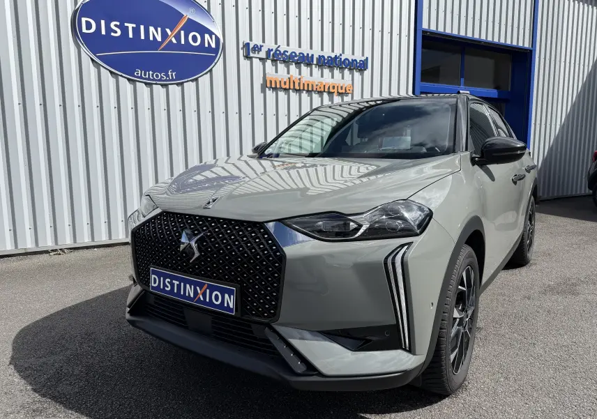 Vue 3/4 avant droite d'une DS3 2024 gris laqué avec toit noir, calandre distinctive et feux LED verticaux marquants.