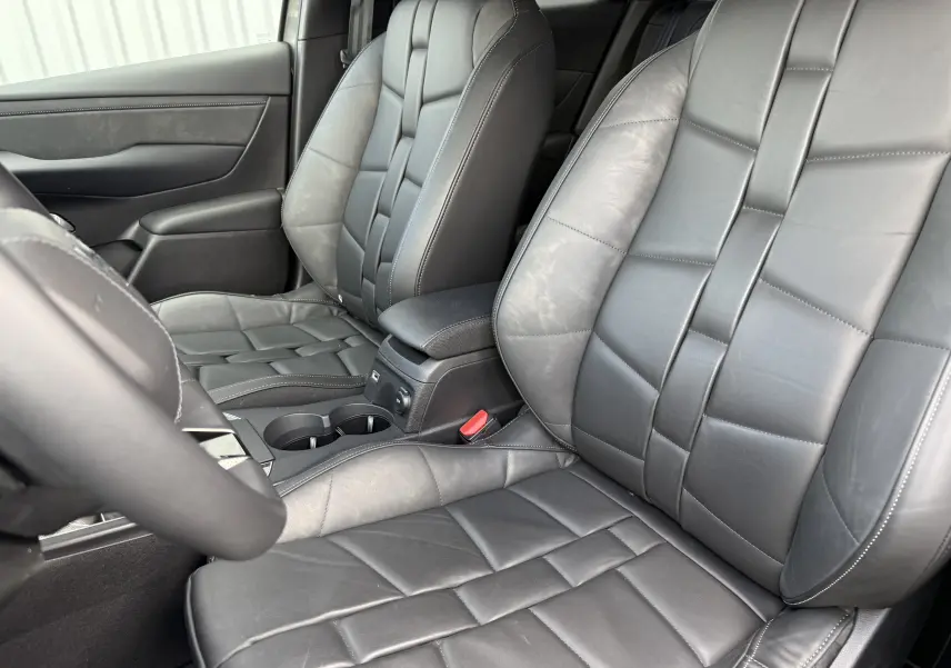 Vue rapprochée des sièges avant en cuir gris du DS3 2024 avec coutures apparentes et accoudoir central.