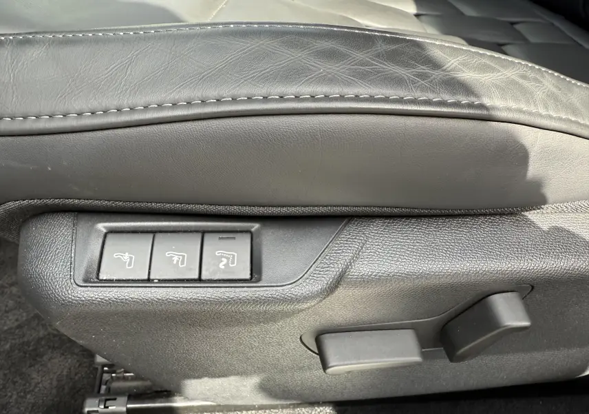Gros plan sur les commandes électriques du siège en cuir gris du DS3 2024 version BlueHDi 130 Opera.