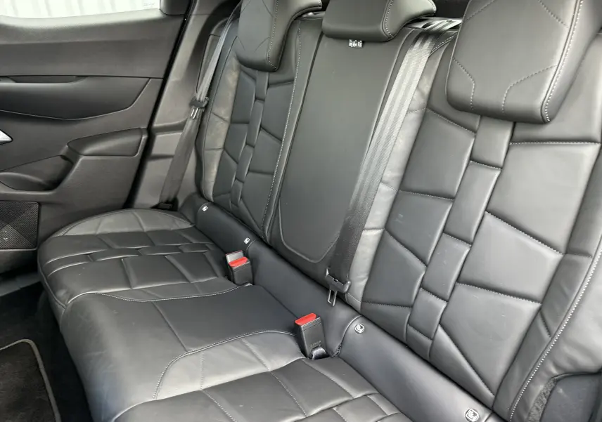 Vue intérieure sur les sièges arrière en cuir noir du DS3 2024, soulignant la finition élégante et les ceintures de sécurité.