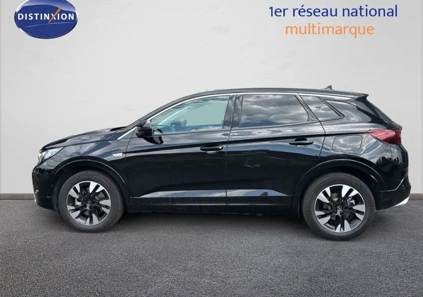Profil côté gauche d'un Opel Grandland noir 2024 hybride rechargeable avec jantes bi-ton et lignes épurées.