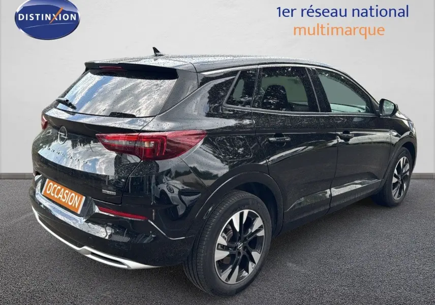 Opel Grandland noir en 3/4 arrière droit, hybride rechargeable, jantes bi-ton et feux arrière LED visibles.