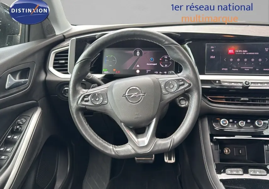 Vue intérieure frontale du volant en cuir noir et du tableau de bord numérique de l'Opel Grandland 2024 hybride rechargeable.