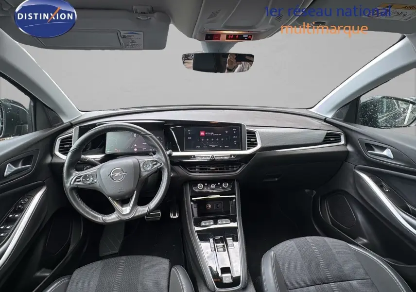 Intérieur noir de l'Opel Grandland 2024, vue frontale du poste de conduite avec tableau de bord numérique et écran tactile central.