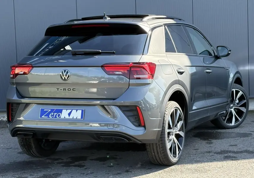 Vue 3/4 arrière droite d'un Volkswagen T-Roc gris Indium avec jantes alliage 19 pouces et vitres teintées.
