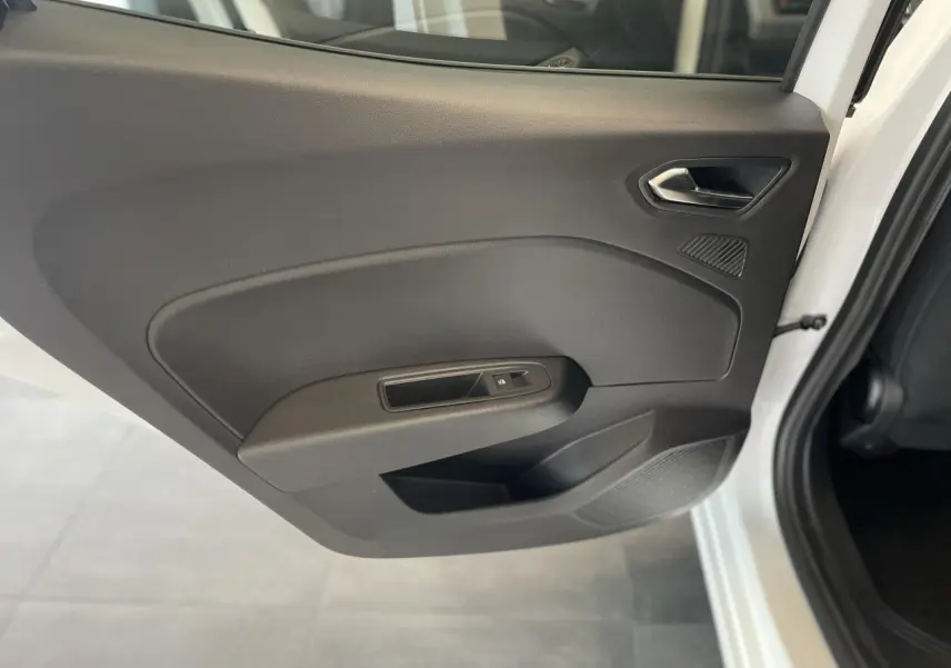Vue rapprochée de la porte arrière droite noire de la Renault Clio 1.5 Blue dCi blanche avec poignée et commande de vitre.