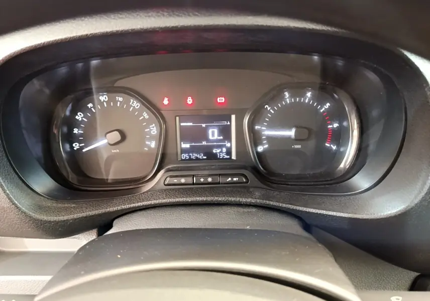 Gros plan sur le tableau de bord du Toyota Proace Verso gris clair, affichant le compteur et les voyants allumés.