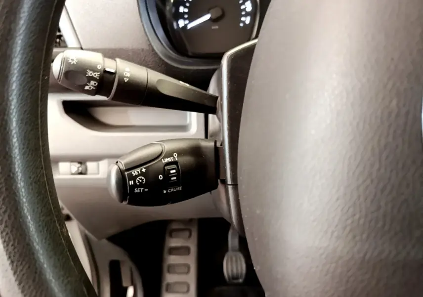 Gros plan sur la commande du régulateur de vitesse et des phares derrière le volant du Toyota Proace Verso gris clair 2019.