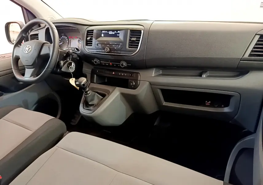 Intérieur du Toyota Proace Verso 2019 en vue avant droite, montrant tableau de bord noir et sièges gris clair.