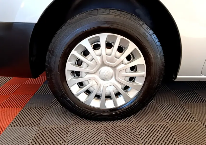 Gros plan sur la roue avant droite d'un Toyota Proace Verso gris clair de 2019 avec enjoliveur argenté et logo Toyota.