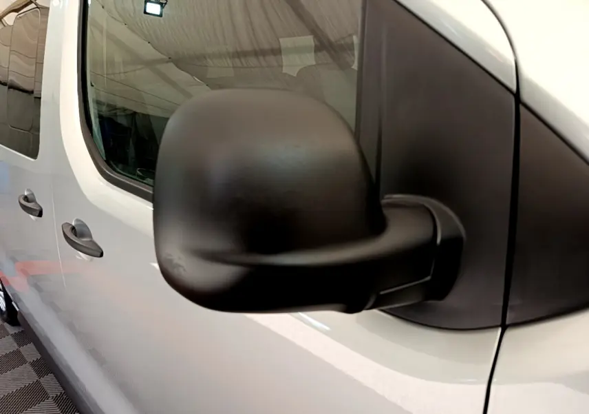 Rétroviseur noir en gros plan côté gauche d'un Toyota Proace Verso gris clair 2019, vue latérale partielle.