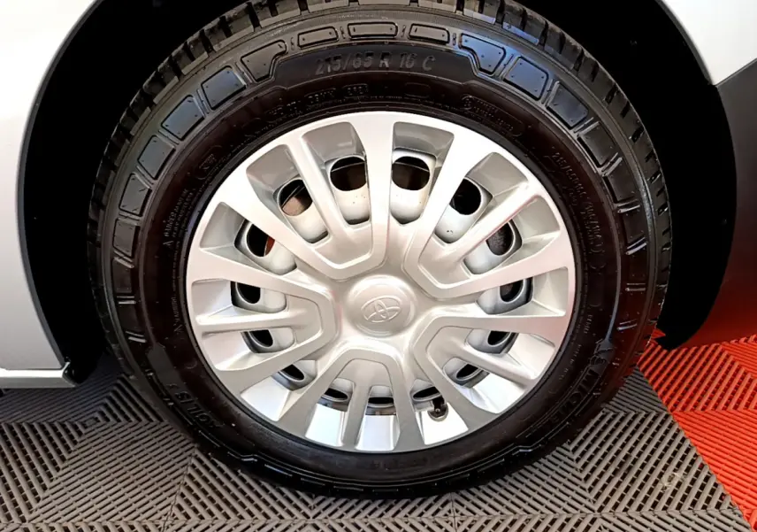 Gros plan sur la roue avant droite du Toyota Proace Verso gris clair, mettant en valeur la jante acier et le pneu neuf.