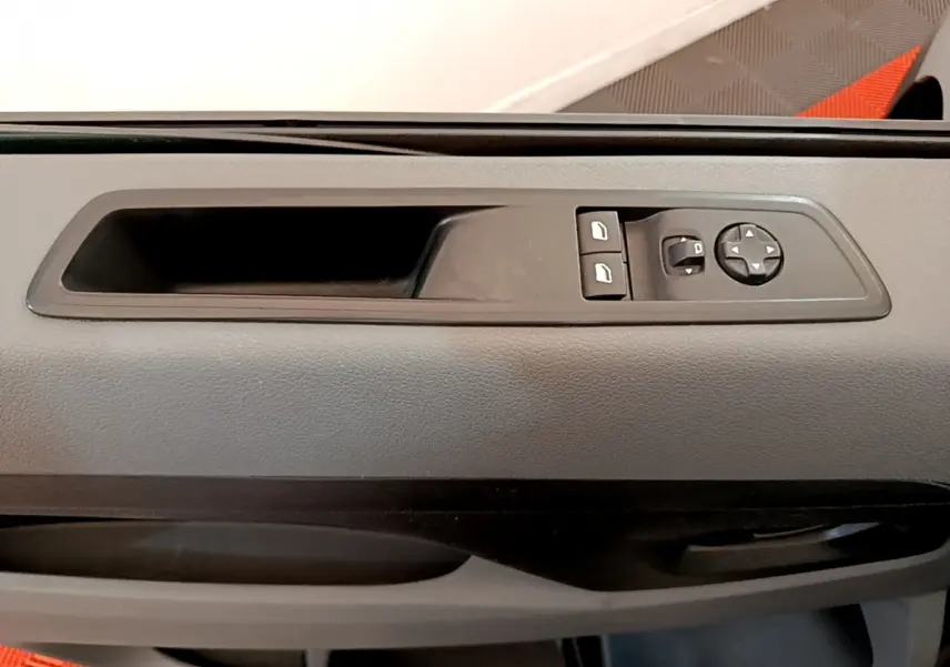 Gros plan sur la commande des vitres et rétroviseurs côté conducteur dans l'habitacle gris du Toyota Proace Verso 2019.
