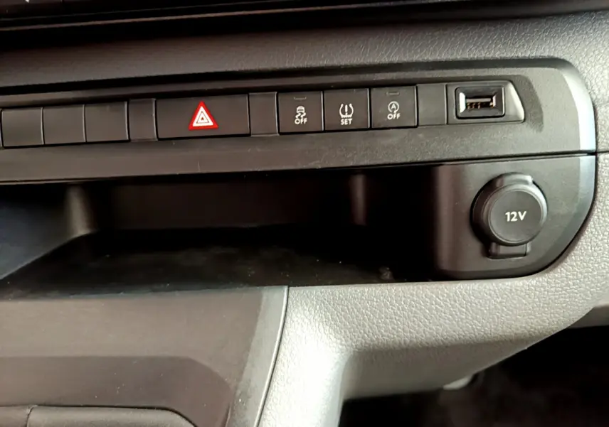 Gros plan sur la console centrale noire du Toyota Proace Verso 2019 avec boutons de sécurité et prise 12V visible