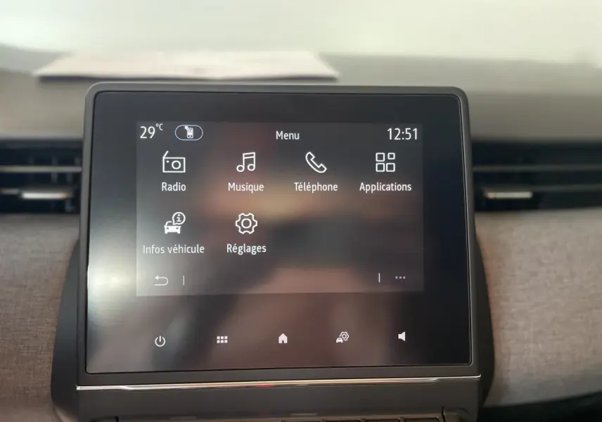 Écran tactile central de la Renault Clio blanche 2025 affichant le menu multimédia avec radio et téléphone.