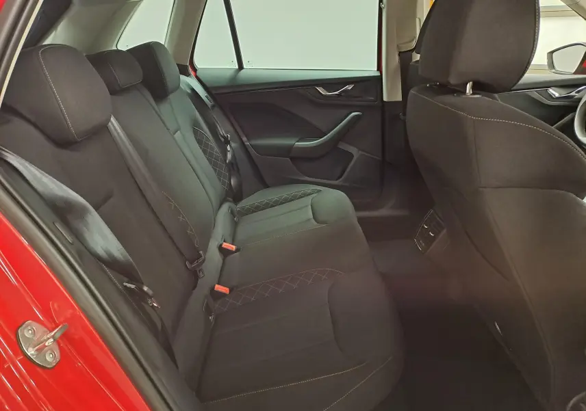 Vue intérieure côté gauche des sièges arrière noirs du Skoda Kamiq 2024 Rouge Velvet avec surpiqûres contrastantes.