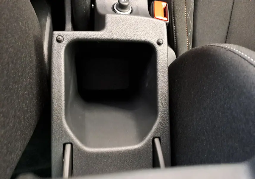 Gros plan sur le rangement central noir entre les sièges avant du Skoda Kamiq 2024 Rouge Velvet.