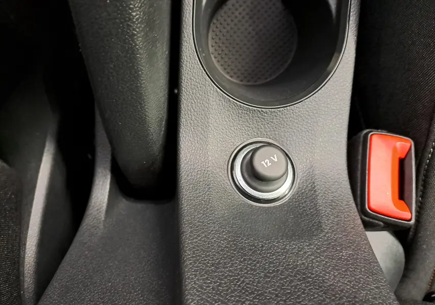 Prise 12 V et bouton de frein à main rouge dans la console centrale du Skoda Kamiq 2024, vue rapprochée intérieure.
