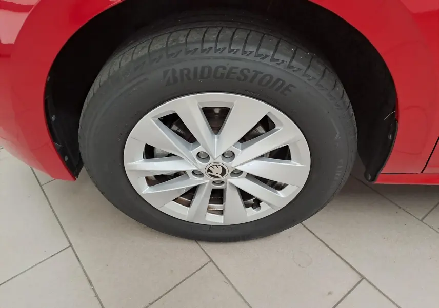 Gros plan sur la roue avant gauche du Skoda Kamiq rouge Velvet avec jante argentée et pneu Bridgestone.